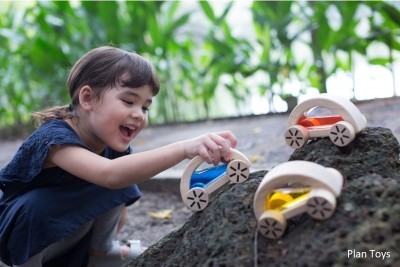 Jouer dehors avec sa petite voiture en bois Wautomobile de Plan Toys